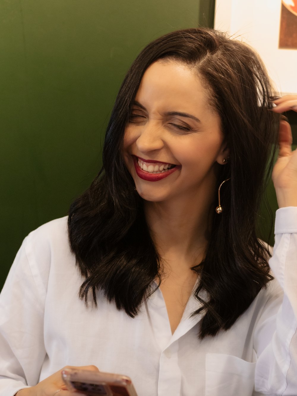 Jessica Araujo sorrindo com o celular na mão